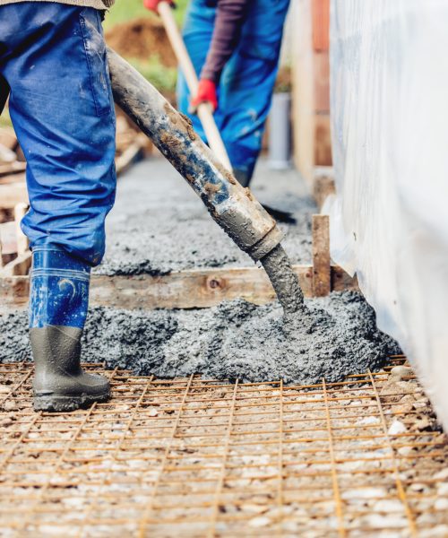 Constuction details - worker laying cement or concrete with automatic pump